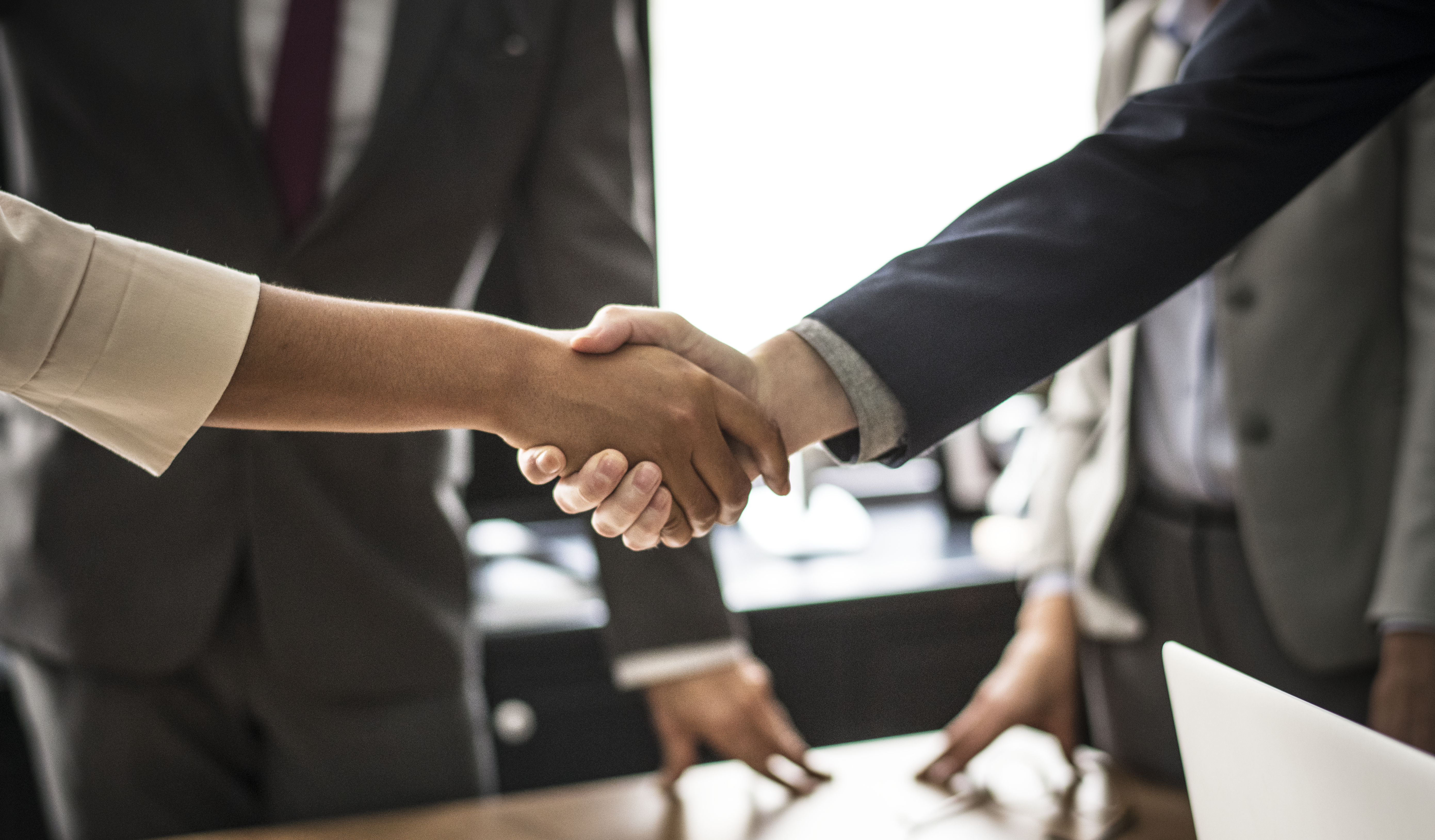 business-people-shaking-hands-meeting-room.jpg