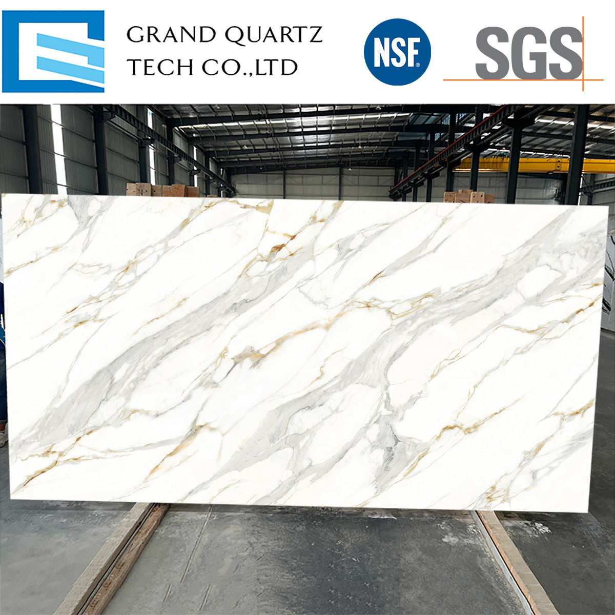 Statuario-Gold-Quartz-slab-featuring-a-soft-white-base-with-delicate-golden-and-gray-veining,-displayed-against-a-light-gray-brick-wall-background..jpg