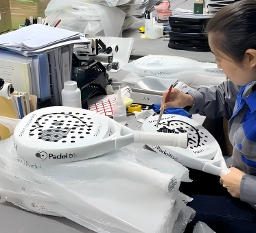 QC inspection Post-processing of padel rackets – deburring holes with file, followed by grip assembly, end cap, wrist strap attachment, and final packaging